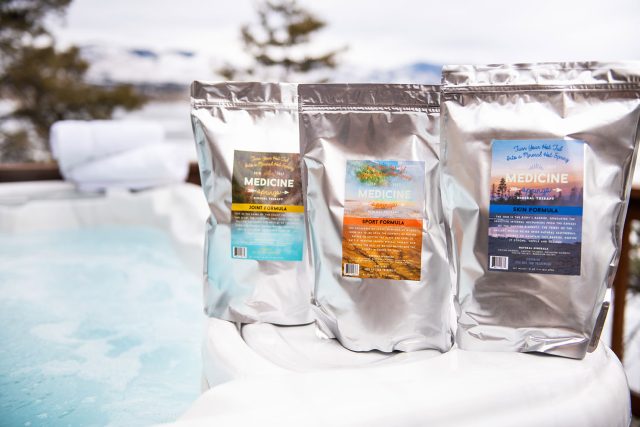 Three pouches of Medicine Springs product. These are the Joint Formula, Sport Formula and Skin Formula mineral therapy sitting on the edge of a hot tub.